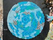 Travis Smith<br/>2017 - 2019<br/><span style= "font-size: 6pt">33.7524825882067, -84.3624765977926</span> Forward Warrior Mural formerly in Cabbagetown Atlanta by Travis Smith featuring a blue circular pattern