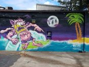 Wolfdog (Ash Hayner)<br/>2017 - 2021<br/><span style= "font-size: 6pt">33.74069520387011, -84.3466394255961</span> Street art mural formerly in East Atlanta Village by Wolfdog featuring a surfer in the moonlight