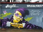 Gus Cutty<br/>2017 - 2020<br/><span style= "font-size: 6pt">33.7473300698253, -84.38130195086578</span> Street Art Mural formerly in Capital Gateway Atlanta by Gus Cutty featuring a man wearing a purple hat