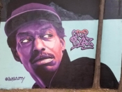 Gus Cutty<br/>2018 - 2024<br/><span style= "font-size: 6pt">33.75102179121776, -84.36754028950284</span> Forward Warrior mural formerly in Cabbagetown Atlanta by Gus Cutty featuring a purple face with a hat