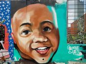 Lonnie Garner<br/>2018 - 2020<br/><span style= "font-size: 6pt">33.7524438086113, -84.36264985274393</span> Forward Warrior Mural formerly in Cabbagetown Atlanta by Lonnie Garner fearuting a toddler's face