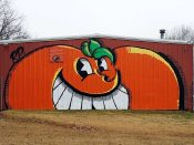 Atomik<br/>2018 - 2021<br/><span style= "font-size: 6pt">33.716192831134045,-84.38021057253559</span> Street Art Mural formerly in South Atlanta by Atomik featuring a smirking orange