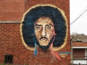 Fabian Williams<br/>2019 - 2022<br/><span style= "font-size: 6pt">33.76586991641097, -84.40484216249153</span> Street Art Mural formerly in West Atlanta by Fabian Williams featuring an image of Colin Kaepernick