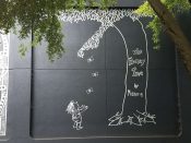 Mister E<br/>2020 - 2022<br/><span style= "font-size: 6pt">33.782506, -84.383675</span> Street Art Mural formerly in Midtown Atlanta by Mister E featuring a boy standing under a money tree