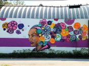 Eric Nine<br/>2020 - 2022<br/><span style= "font-size: 6pt">33.748105335715685, -84.40132076109687</span> Street Art Mural formerly in Castleberry Hill Atlanta by Eric Nine featuring a woman with Flowers in her hair