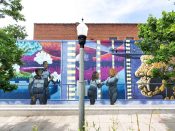 Tim Short<br/>2022 - 2024<br/><span style= "font-size: 6pt">33.77484814119092,-84.2957454174757</span> Street art mural formerly in Decatur Georgia by Tim Short featuring people in space suits