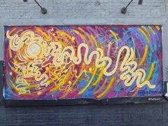Street Art Mural in East Lake Atlanta by Ethreo featuring a yellow squiggle