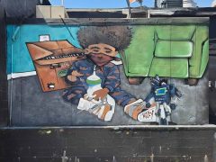 Street Art Mural in Little Five Points Atlanta by Killy featuring a child wearing a mask
