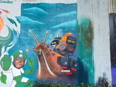 Street Art Mural in Cabbagetown Atlanta by Skape Zilla featuring a snail with speakers on it's back
