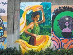 Street Art Mural in Cabbagetown Atlanta by Trudy Tran and Krispyaki (Aki Tran) featuring a woman with yellow fans.